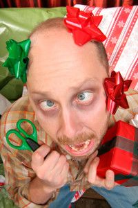 Overwhelmed man wrapping gifts