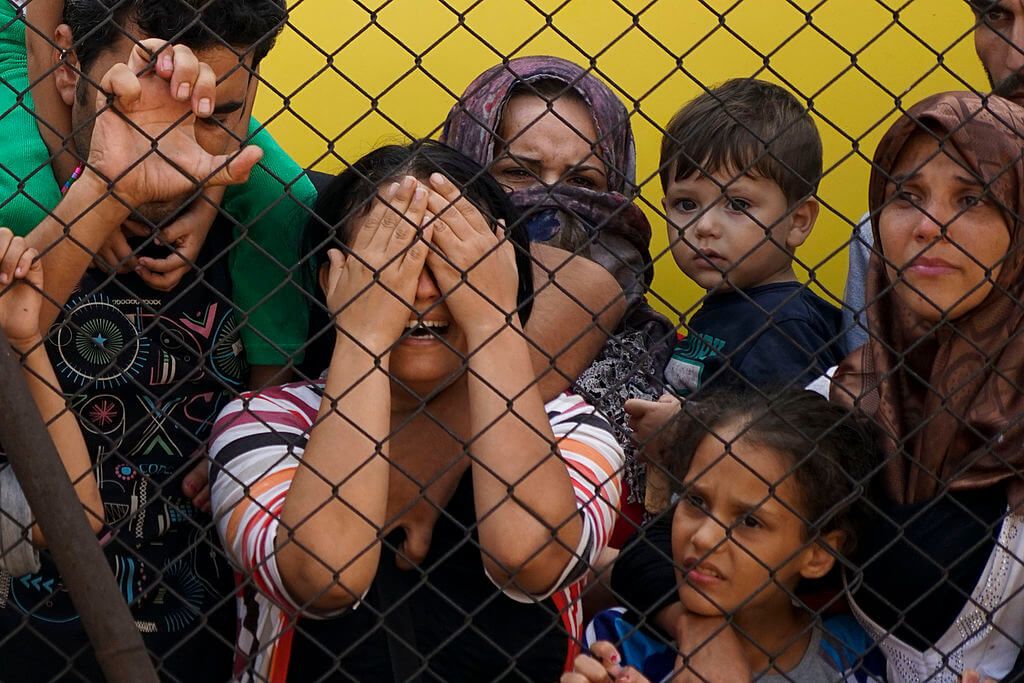Syrian refugees behind a fence