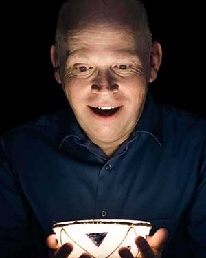 Christian magician Brad Brown holding a glowing bowl.